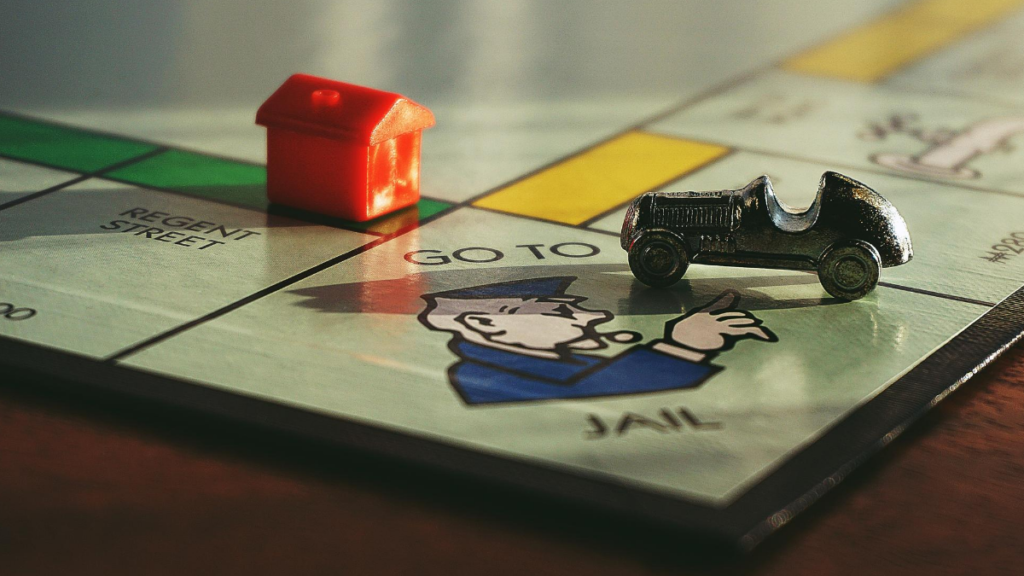 A picture of a monopoly board (just the corner) with a house on it to represent taking advantage and the house. 