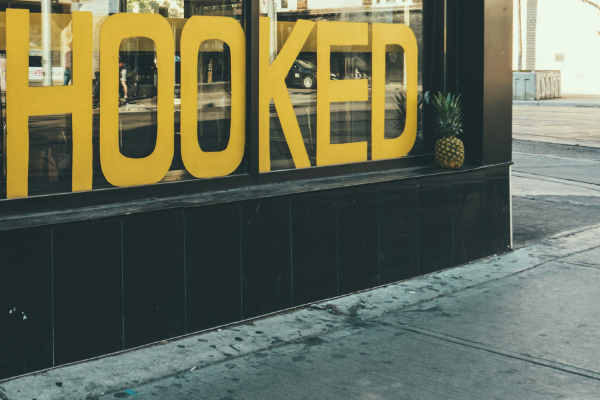 A picture of signage in a window that says, "hooked"