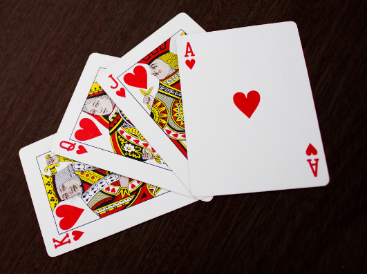 A picture of fanned out playing cards. All the same suit (hearts), Ace, king, queen and jack..