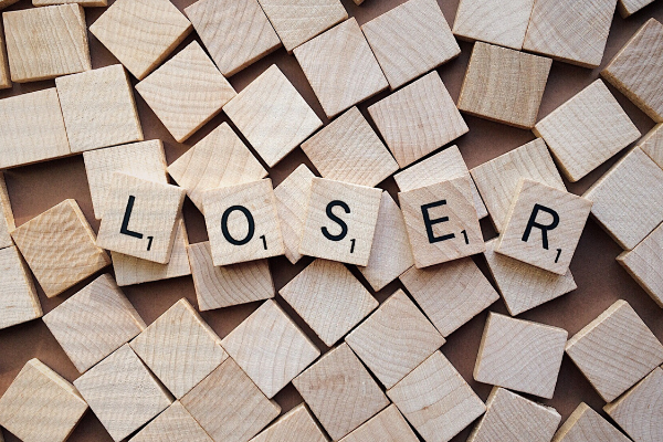 A picture of lots of wooden squares with letters on 5 of them that spell "loser"